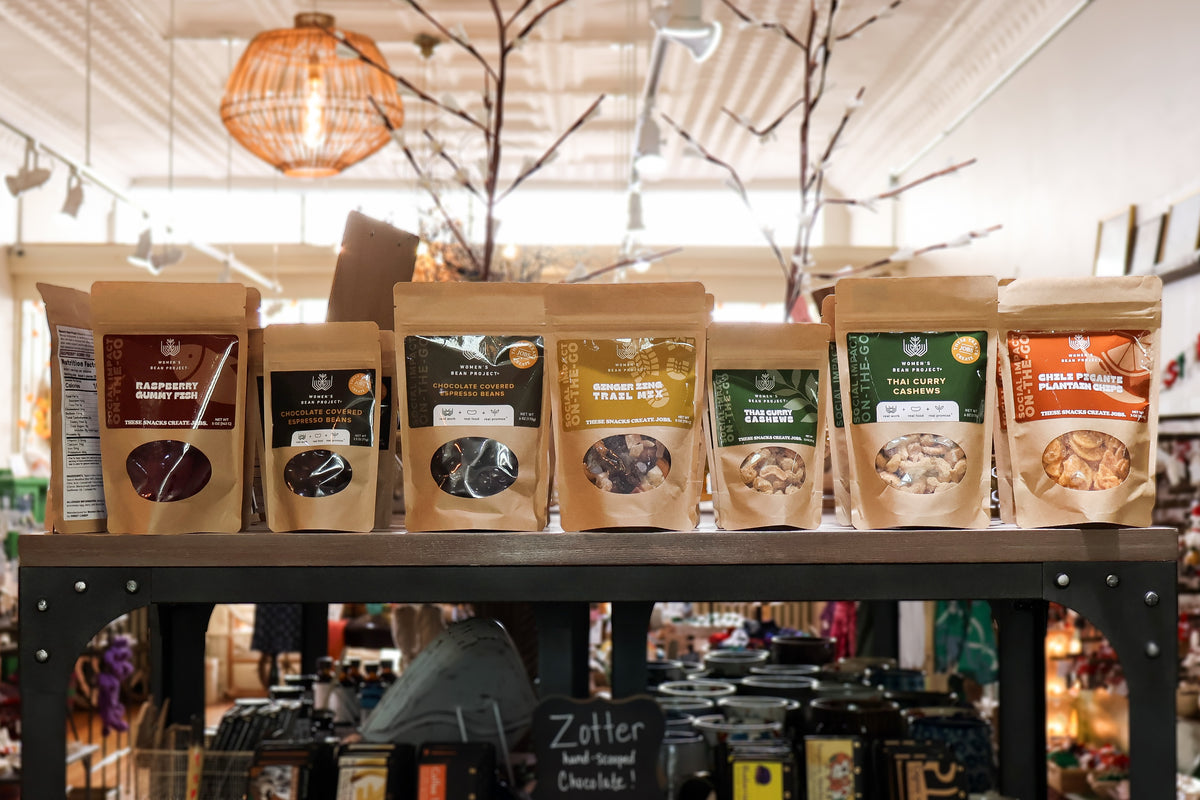 A row of Women's Bean Project snacks on a shelf in Latitudes Fair Trade Staunton.