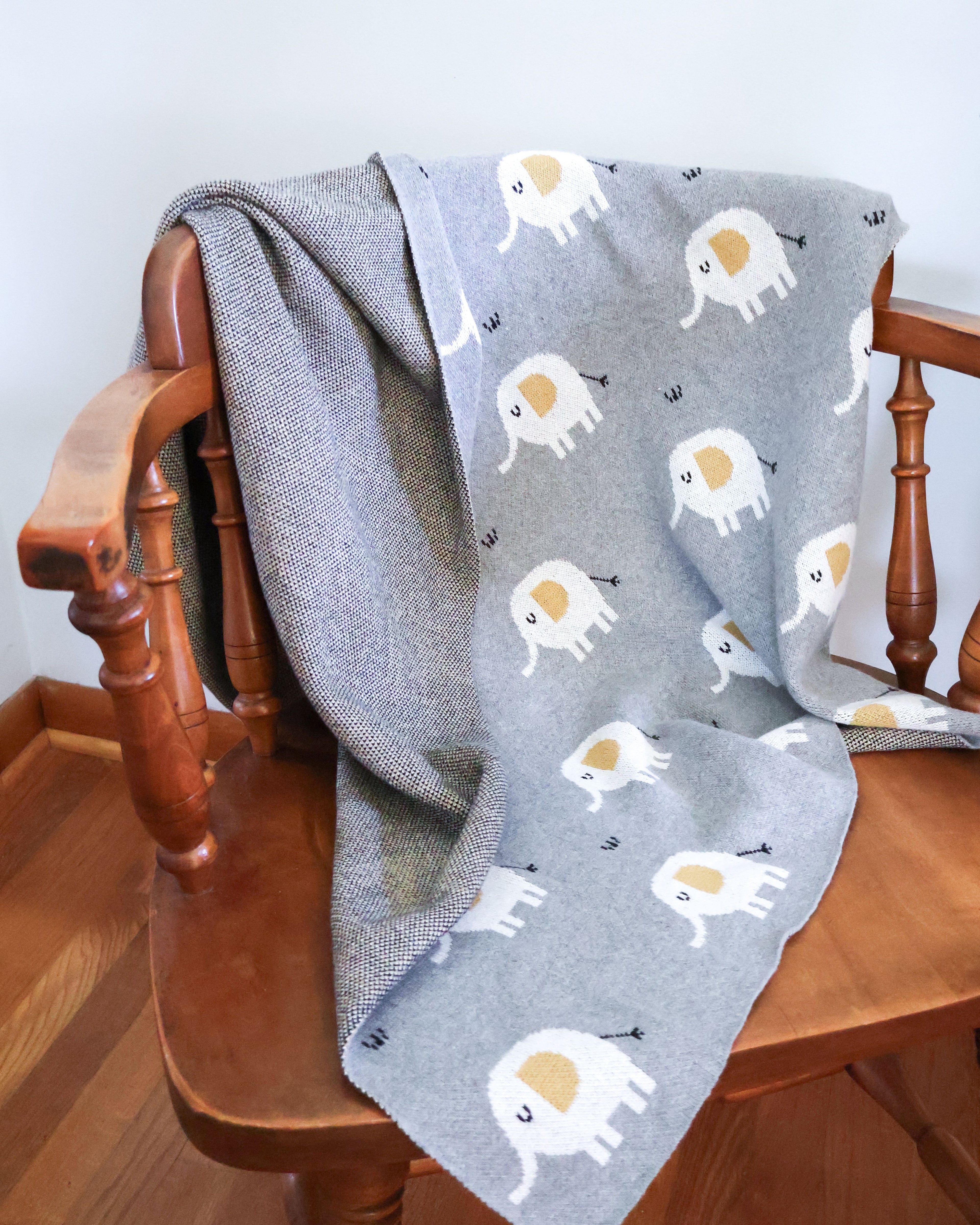 Grey baby blanket with elephant pattern on a chair